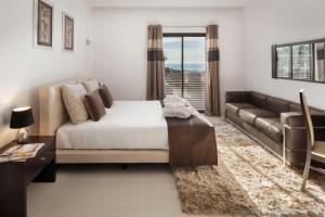 a bedroom with a bed and a couch at Belmar Spa & Beach Resort in Lagos