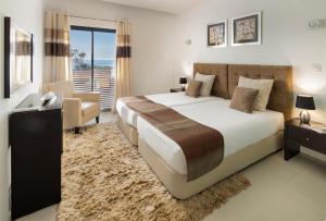 a bedroom with a bed and a desk and a chair at Belmar Spa & Beach Resort in Lagos