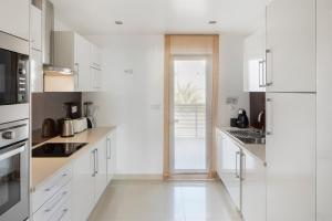a white kitchen with white cabinets and appliances at Belmar Spa & Beach Resort in Lagos
