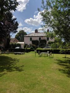 Casa blanca con patio con sillas y árboles en Marley House Bed and Breakfast, en Winfrith Newburgh