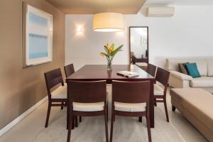 a dining room with a table and chairs and a couch at Belmar Spa & Beach Resort in Lagos