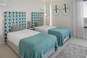 two beds in a bedroom with blue and white at Belmar Spa & Beach Resort in Lagos