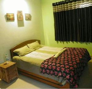 a small bedroom with a bed and a table at NILESH COTTAGE in Alibaug