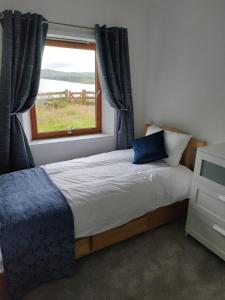 a bedroom with a large bed with a window at The Old Crofthouse, Kingsburgh in Kingsburgh