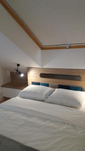 a bedroom with a large white bed with a cross on it at Apartament Limanowskiego in Kraków