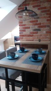 drewniany stół z czterema czarnymi miseczkami w obiekcie Apartament Limanowskiego w Krakowie