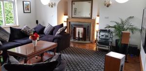 a living room with a couch and a fireplace at Wychwood House in Tenby