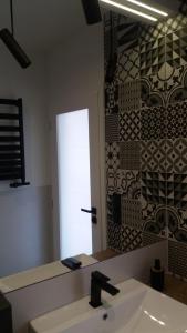 W łazience znajduje się umywalka i lustro. w obiekcie Apartament Limanowskiego w Krakowie