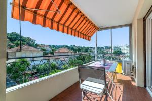 a balcony with a table and chairs and a view at COPACABANA appartement 2 chambres in Cannes