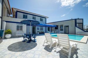 a patio with a table and two chairs and an umbrella at Hotel Pousada do Farol in Aracaju