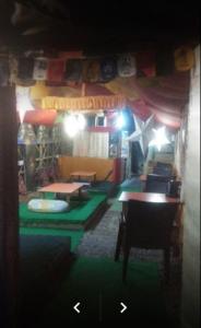 a room with a room with a table and chairs at Shanti Cafe and Guest House Mcloedganj in Dharamshala