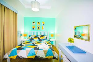 - une chambre avec un lit coloré et un lavabo dans l'établissement Charming Modern 2-Bedroom Apartment, Olongapo City Center, à Olongapo