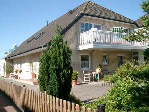 a house with a fence in front of it at Ferienwohnung Südhoff in Horumersiel