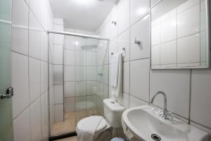 a white bathroom with a toilet and a sink at Cariacica Hotel in Cariacica +42 photos