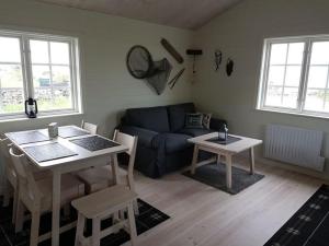 uma sala de estar com uma mesa e um sofá em Sjötorpet - unikt boende vid havet på norra Öland! em Löttorp