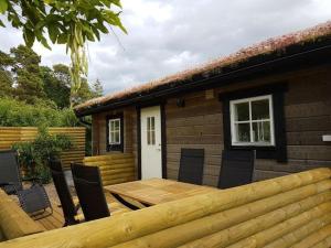 una mesa de madera y sillas frente a una casa en Sjötorpet - unikt boende vid havet på norra Öland! en Löttorp