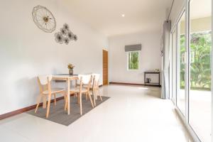a dining room with white walls and a table and chairs at AKARD Private Villas Sattahip in Sattahip