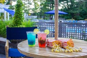 a wooden table with two drinks and snacks on it at Admiral's Inn Resort in Ogunquit