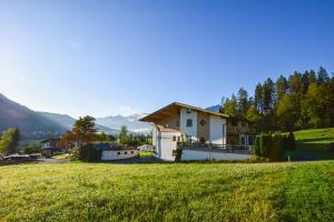 ein Haus auf einem grünen Feld in der Unterkunft Hutmann in Kirchdorf in Tirol