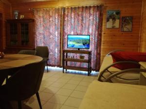 a living room with a television and a table and chairs at De Zon B&B in Heist-op-den-Berg