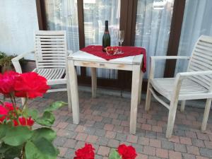 een tafel met een fles wijn en twee stoelen bij De Zon B&B in Heist-op-den-Berg