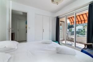 two beds in a bedroom with a large window at COPACABANA appartement 2 chambres in Cannes