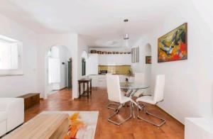 Il dispose d'une cuisine et d'un salon avec une table et des chaises en verre. dans l'établissement casa zaffiro, à Taormine