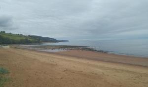 a sandy beach next to the ocean on a cloudy day at Hillhaven Bed &Breakfast in Fortrose