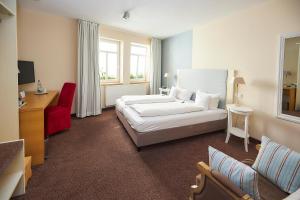 バート・ヴィンツハイムにあるFlair Hotel zum Storchenのベッドとソファ付きのホテルルーム