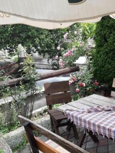a picnic table and chairs in a garden with roses at MS Stojic in Nova Varoš