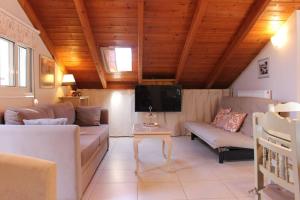 a living room with a couch and a tv at New independent loft, 360⁰ view, 5' beach/center in Kalamata