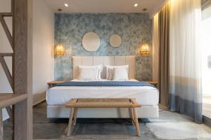 a bedroom with a large white bed and a bench at Notia Luxury Living in Porto Koufo