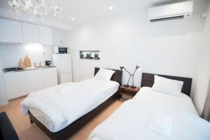 Cet hébergement comprend 2 lits dans une chambre dotée de murs blancs et de placards blancs. dans l'établissement Salon Shibuya - Vacation STAY 78187, à Tokyo