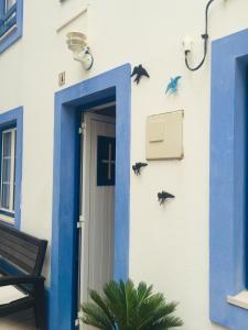 une porte bleue avec des oiseaux sur le côté du bâtiment dans l'établissement A casinha do Pescador, à Nazaré
