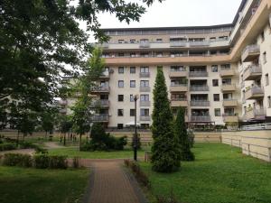 an apartment building in a park with a path at W Krakowie u Helenki in Krakow