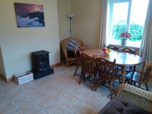 a dining room with a table and a wood stove at Rossnowlagh Creek Holiday House in Rossnowlagh