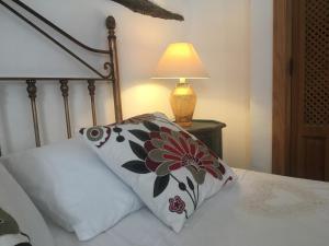 a bed with a pillow and a lamp on a table at Casa Cervantes in Alhama de Granada