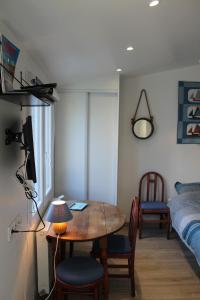 ein Zimmer mit einem Tisch und ein Schlafzimmer mit einem Bett in der Unterkunft Petit studio CYPRÈS du BOIS in Noirmoutier-en-l'lle