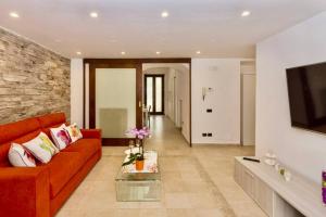 een woonkamer met een rode bank en een tv bij Sara luxury apartament 2 in Sorrento