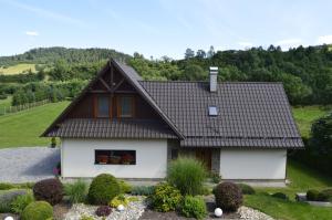 uma pequena casa com telhado castanho em Ubytovanie Lenka em Osturňa