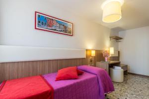 una camera con letto viola e cuscino rosso di Hotel Il Moro di Venezia a Venezia