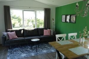 a living room with a black couch and a table at Minicamping Zonnehoek in Biggekerke