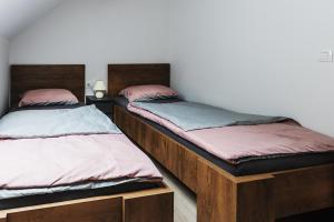 two beds in a room with wooden beds at APARTMAJI GORENC in Bled