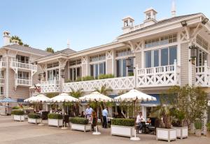 un grand bâtiment avec des tables et des parasols devant lui dans l'établissement Shutters On The Beach, à Los Angeles