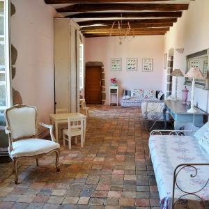 a living room with chairs and a couch and a table at Les Chambres du Logis du Chatelier in Bressuire