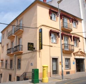 un edificio amarillo en la esquina de una calle en Hotel Dora, en Plasencia