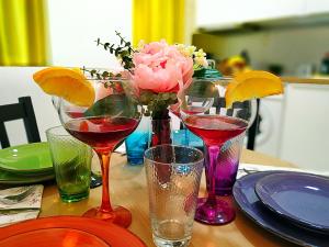 uma mesa com quatro taças de vinho e um vaso de flores em Apartamento junto a Calle Larios em Málaga