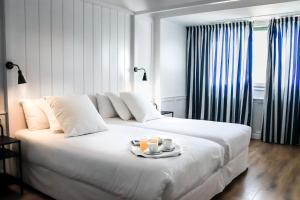 a white bed with a tray of food on it at Hotel Marina in Palamós