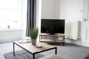 a living room with a tv and a coffee table at Waterloo Lodge in Norwich