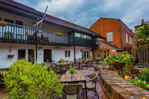 an outdoor patio with tables and chairs and a building at The Feathers Hotel, Ledbury, Herefordshire in Ledbury